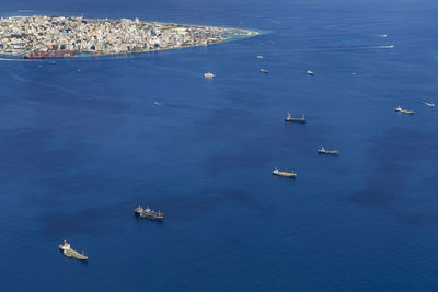 Cargo ships floating near the male city capital of maldives, view from seaplane window