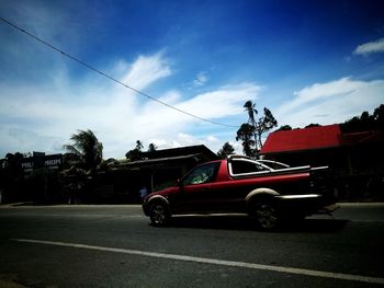 Cars on road against sky in city