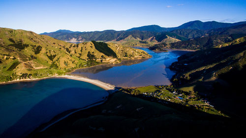 Scenic view of lake and mountains against blue sky