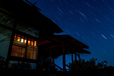 Low angle view of illuminated stage against sky at night