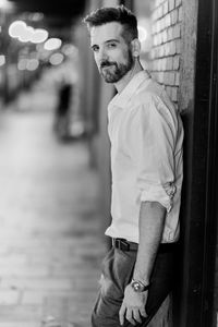 Portrait of smiling mature man leaning on wall