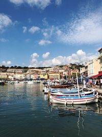 Boats in harbor against buildings in city