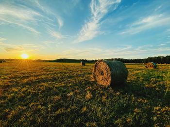 Hay bales on field against sky