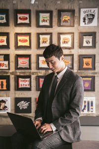 Full length of a young man standing against wall