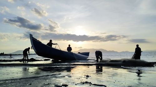 Fishermen clean up nets on the beach after fishing in banda aceh