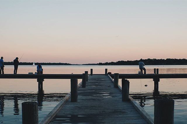 water, pier, copy space, the way forward, tranquil scene, railing, clear sky, tranquility, sunset, sea, scenics, jetty, nature, beauty in nature, men, boardwalk, silhouette, sky, idyllic