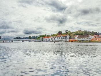 View of boats in river against cloudy sky