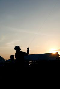 Silhouette of man against sky at sunset