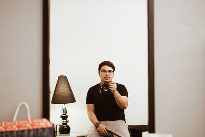 Portrait of man standing against wall