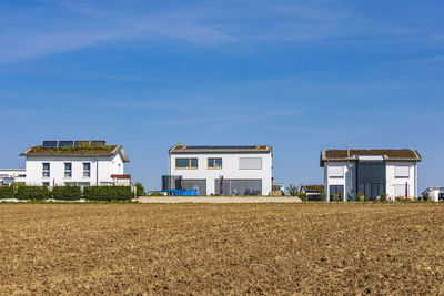 Germany, baden-wurttemberg, sindelfingen, field in front of modern suburban houses