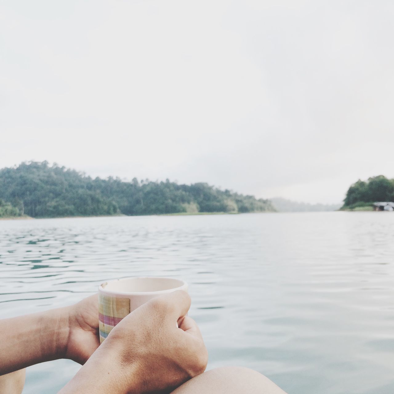 person, personal perspective, water, part of, cropped, lake, holding, lifestyles, leisure activity, unrecognizable person, human finger, sky, tranquility, clear sky, tranquil scene, nature, scenics