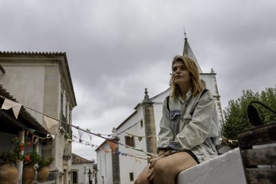 Low angle view of woman building against sky