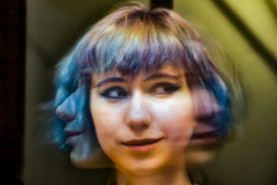 Blurred motion of thoughtful young woman with dyed hair