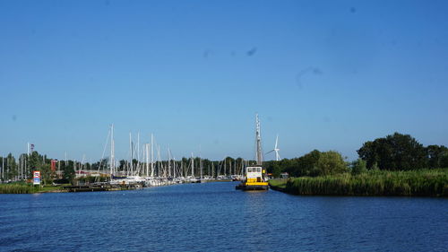 Sailboats on sea against clear blue sky