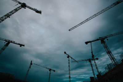 Low angle view of cranes against sky