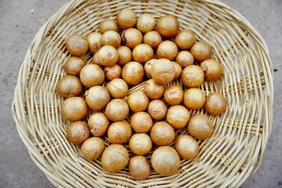 High angle view of macadamia nuts with shell in basket