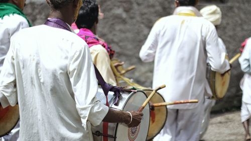 Rear view of men playing drums