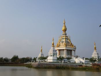 Temple by lake against sky