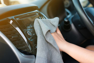 Cropped image of woman with textile sitting in car