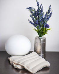 Close-up of white flower vase on table against wall