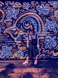 Full length of woman standing on graffiti
