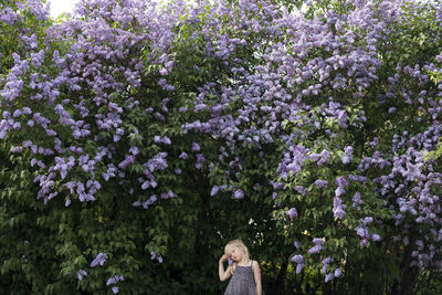 Girl standing by blooming trees