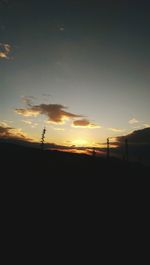 Scenic view of silhouette field against sky during sunset