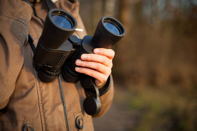 Midsection of man holding camera