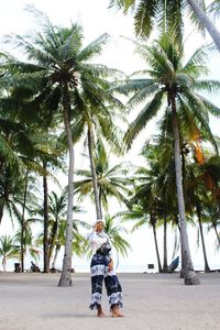 Rear view of man and palm trees