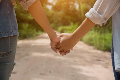 Midsection of couple holding hands