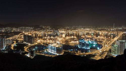 High angle view of illuminated cityscape against sky at night