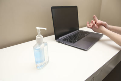 Midsection of man using laptop on table