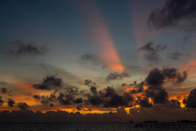 Sunset background and sun beam on the open sea with beautiful clouds.