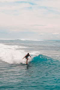 Man surfing in sea against sky