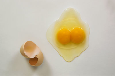 High angle view of yellow eggs against white background