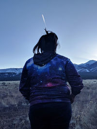 Woman walking against clear blue sky