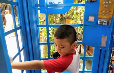 Boy talking through pay phone