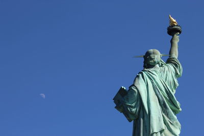 Low angle view of statue against blue sky