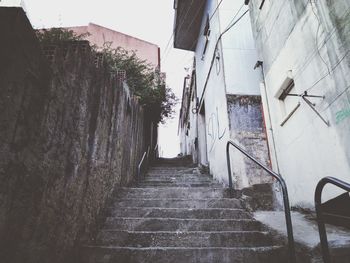 Steps amidst buildings against sky