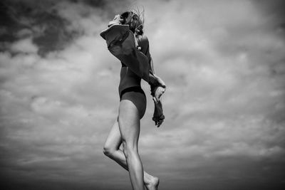 Low angle view of woman standing against sky