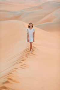 Woman standing on sand dune