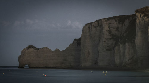 Rock formations by sea against sky