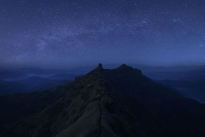 Scenic view of mountains against sky at night