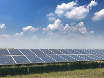 Solar panels of field against blue sky