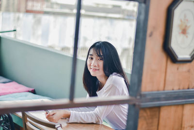 Portrait of young woman sitting outdoors