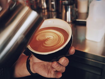 Close-up of hand holding coffee cup