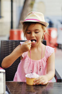 Girl eating ice cream at outdoor cafe