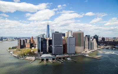High angle view of east river by modern buildings against cloudy sky