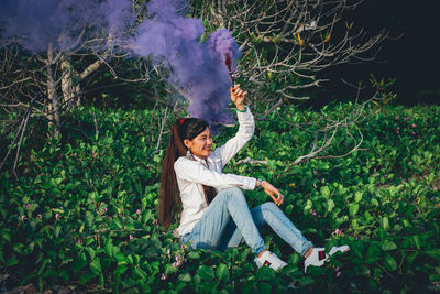 Woman sitting on plant by land