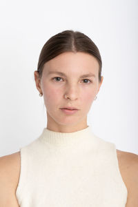 Portrait of young woman against white background